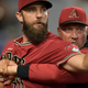 Madison Bumgarner is restrained by a coach.
